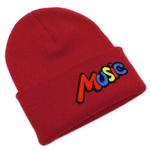 Close-up of colorful MUSIC embroidery detail on red knitted beanie hat with soft texture