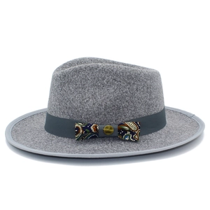 Macro view of grey wool fedora hat featuring detailed paisley bow and vintage metal buckle