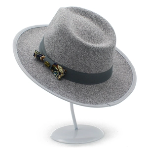 Classic light grey wool fedora hat with paisley bow and gold button detail on white stand