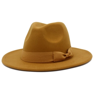 Detail view of ginger yellow wide brim fedora hat with elegant ribbon bow decoration