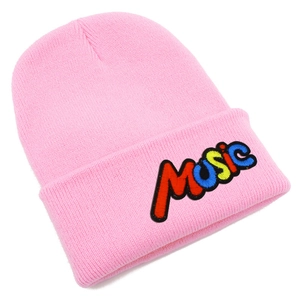 Detail of pink knitted beanie featuring colorful MUSIC embroidery on the folded cuff