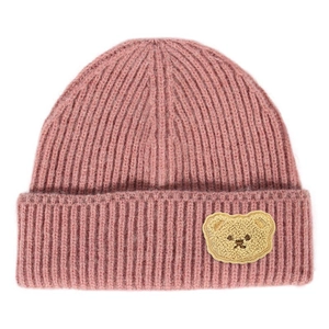Detailed view of pink knitted beanie with a yellow teddy bear patch and ribbed texture