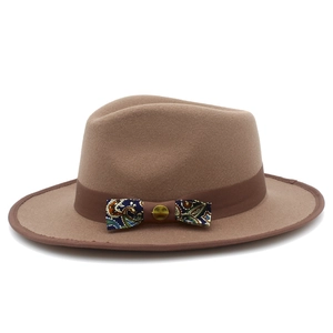 Detail of wool fedora hat with paisley pattern bow and vintage gold buckle on brown ribbon