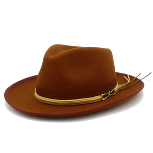 Detail view of the caramel fedora hat featuring a burgundy band and leather fringe accents
