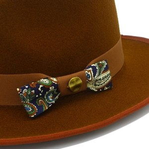 Detail of wool fedora hat with paisley pattern bow and antique gold metal buckle