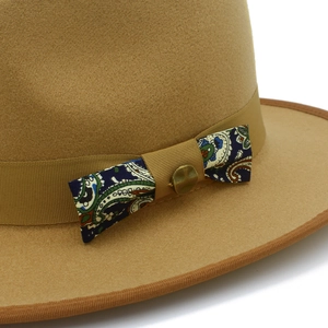 Close-up of wool felt fedora with elegant paisley bow detail and vintage bronze button