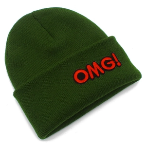 Detailed view of dark green knit beanie featuring a red OMG! embroidered letter patch