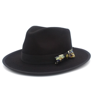 Close-up of black wool fedora with paisley bow and vintage gold button detail