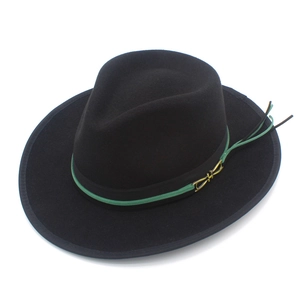 Detail of black wool fedora hat featuring green tassel trim and gold metallic buckle