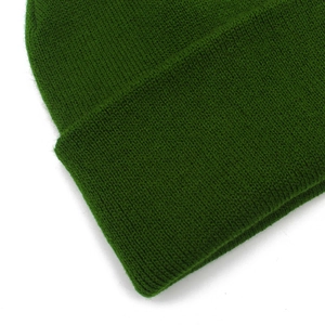 Detailed macro view of dark green ribbed knit texture on a warm winter beanie hat
