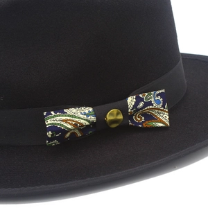 Detail of wool fedora hat with paisley bow tie and antique bronze metal buckle