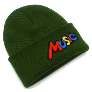 Detail of MUSIC embroidered patch on a dark green knitted beanie with soft ribbed texture