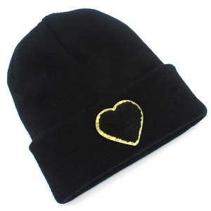 Detail of black knit beanie featuring a heart patch with gold glitter edges and cuffed brim