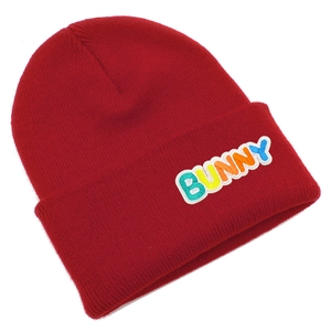 Detail of red knitted beanie featuring colorful BUNNY 3D embroidery and ribbed texture