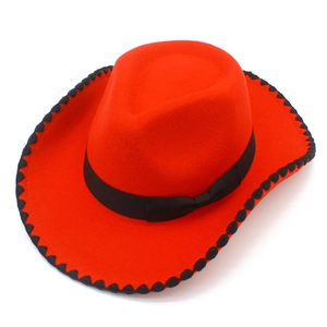 Détail d'un chapeau de cow-boy en feutre rouge avec ruban noir et bordure ondulée
