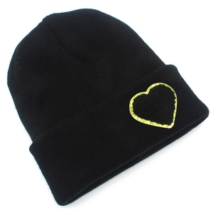 Detailed close-up of a black knit beanie featuring a glittery heart patch texture