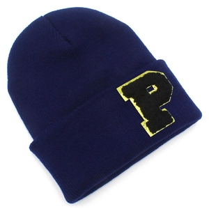 Detail of navy knit beanie featuring a P letter patch with gold trim and fuzzy texture