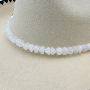 White beaded chain accessory wrapped around a cream wool felt western cowboy fedora hat