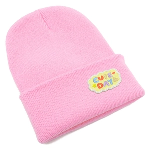 Détail d'un bonnet en maille rose avec écusson brodé Cute Day en forme de nuage