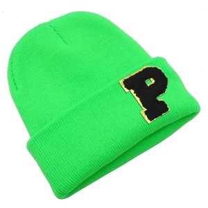 Detailed view of neon green ribbed knit beanie with black and gold letter P patch