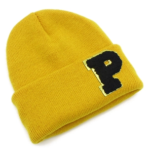 Close-up of ginger yellow knit beanie featuring a black plush letter P patch detail