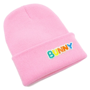 Close-up of pink knit beanie with colorful Bunny embroidery and ribbed texture