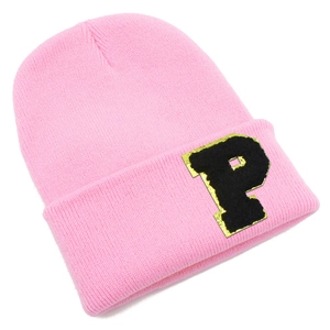 Close-up of pink knit beanie featuring a black letter P patch with gold glitter details