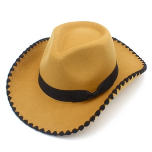 Détail d'un chapeau de cowboy avec bordure noire festonnée et nœud décoratif chic
