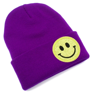 Gros plan du bonnet en tricot violet avec un écusson smiley jaune scintillant