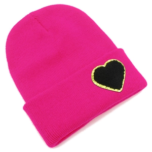 Detail of rose pink ribbed knit beanie featuring a black heart patch with gold sequins