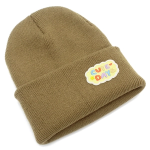 Détail du patch brodé Cute Day sur le revers du bonnet en tricot de couleur kaki