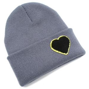 Close-up of grey ribbed knit beanie with black heart patch and golden glitter border