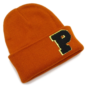 Detail of orange knitted beanie featuring a large black letter P patch with yellow border