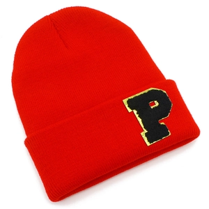 Detail of red ribbed knit beanie showing the black P letter patch with gold embroidery