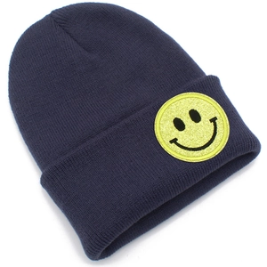 Gros plan détaillé du bonnet en maille bleu foncé avec écusson smiley jaune sur le revers