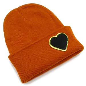 Orange ribbed knit beanie with a stylish black heart patch and golden sequin border