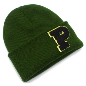 Detail of dark green knit beanie with a stylish P letter patch and golden metallic border