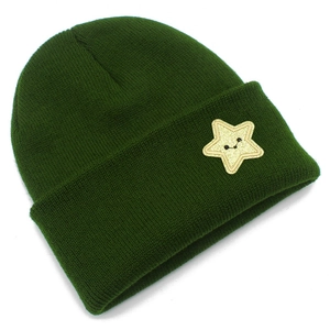 Detail of dark green knit beanie featuring a yellow star patch with a smiley face design