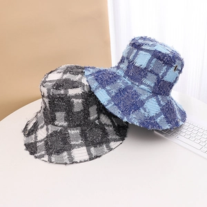 Detailed view of the distressed plaid bucket hat, showcasing the raw frayed edges and texture.