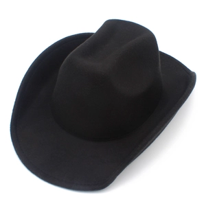Macro side view of a classic black felt cowboy hat with rolled brim and pinched crown