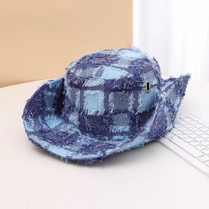 Detailed view of a blue denim checkerboard bucket hat with frayed edges and metal eyelet.