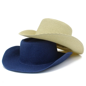 Détail de chapeaux de cowboy en paille tressée bleu marine et beige à larges bords