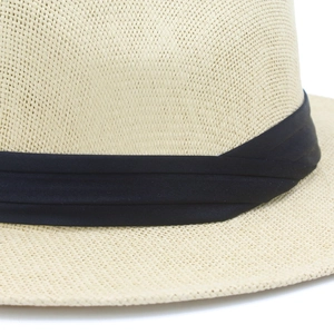 Close-up of fine woven straw texture and elegant black ribbon on a Panama sun hat