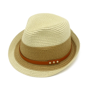 Detailed weave of two-tone straw hat featuring brown leather band and gold rivets