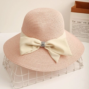 Elegant pink straw sun hat for women with large brim and crystal bow decoration