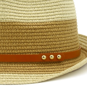 Detail of two-tone woven straw hat with brown leather band and gold rivet accents