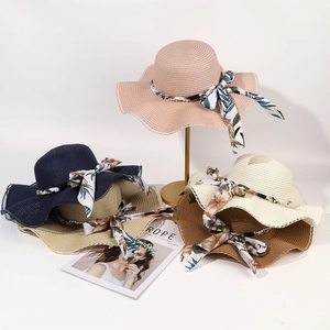 Détail de chapeaux de paille à larges bords avec rubans de soie et fils de perles décoratifs