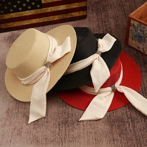 Three classic flat top straw hats in beige black and red colors with ribbon detail