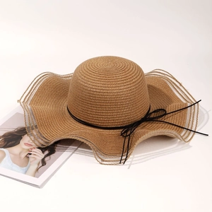 Brown straw beach hat with wavy brim and black bow tie for women summer sun protection