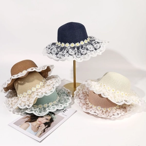 Detail of wide brim straw hats with delicate lace trim and white daisy floral accents